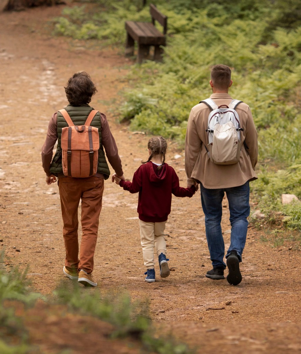 Parents walking on a nature trail with a child.